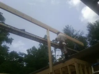 Carpenter setting a ridge beam over a new addition frame — Ice Dam Removal by Roofing Brothers in Springfield